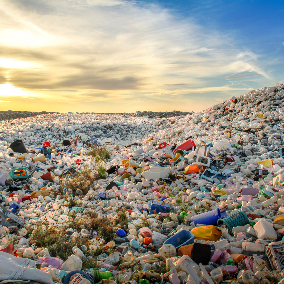 Showing a landfill full of  disposed clothes representing the throwaway culture in a beautiful sunset